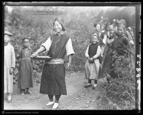 Girl bringing presents to feast at temple, other children in the background, Yunnan, China, November 14, 1917